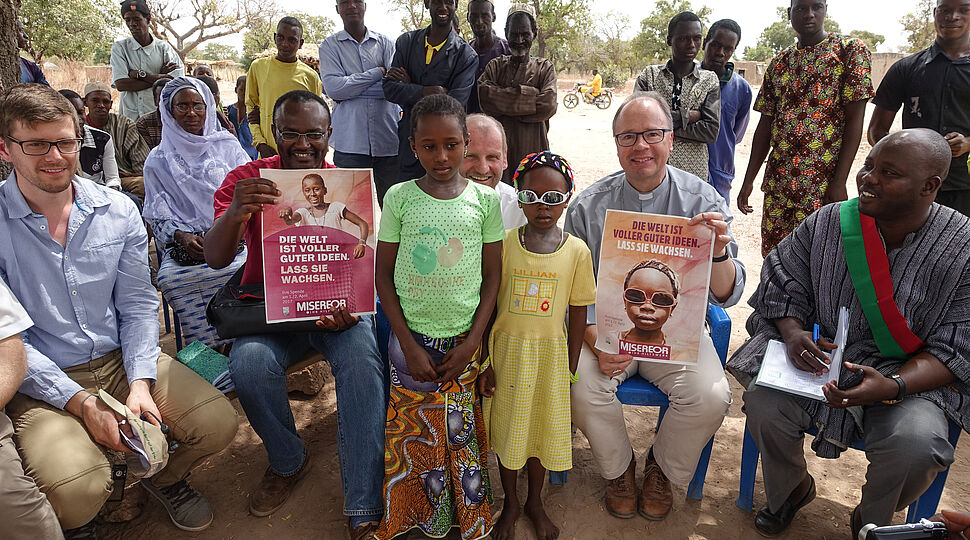 Gruppenfoto mit Bischof, Delegationsmitgliedern und Bewohnern des Ortes in Burkina Faso. Hilfswerke_170213-93-000053.jpg